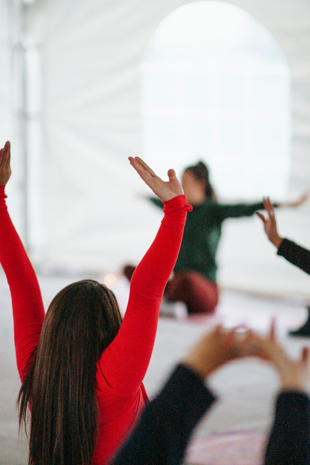 woman-in-red-long-sleeve-shirt-raising-her-hands-fzjopdoanim